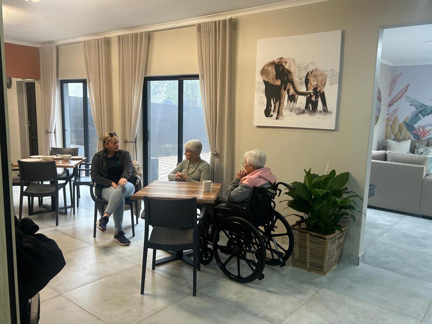 Residents sitting together in the Home Angels lounge, one of them in a wheelchair