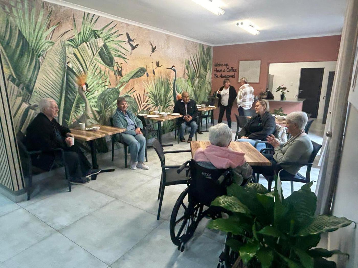 Residents sitting at tables in the Home Angels coffee room