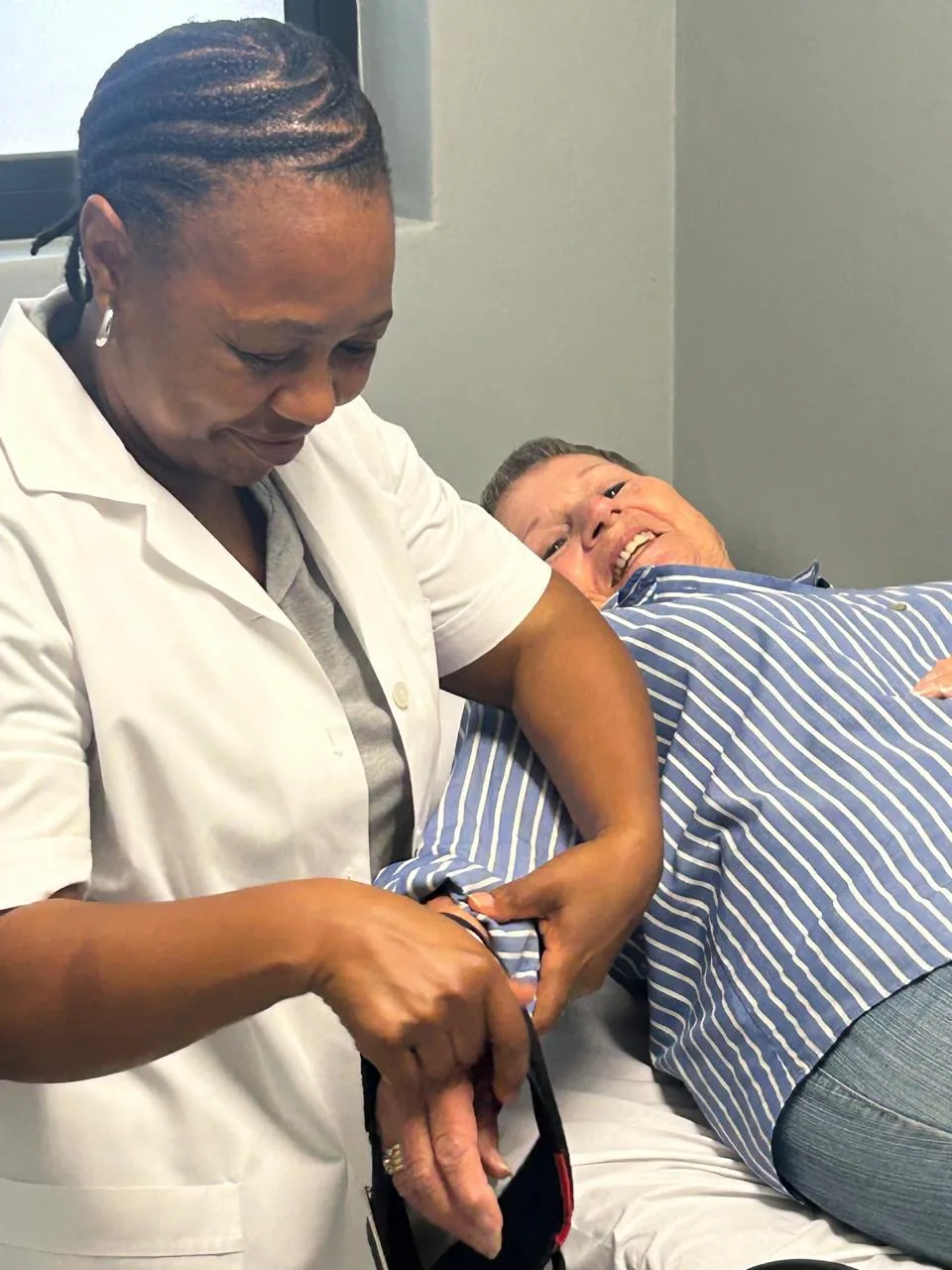 A nurse taking a resident's blood pressure in the treatment room